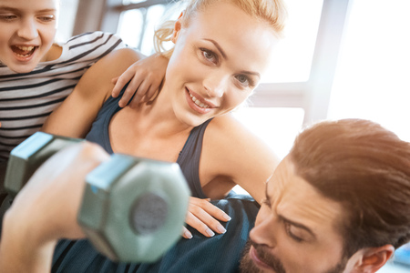 family having fun at gym, man holding dumbbellsの写真素材