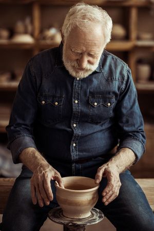 Senior potter making pottery on a wheelの写真素材