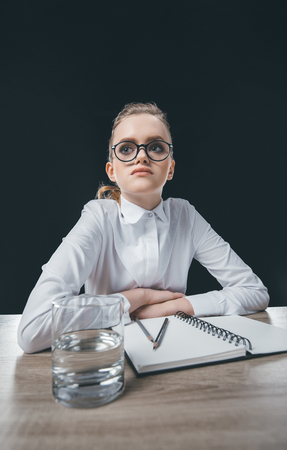 woman in eyeglasses sitting at tableの写真素材
