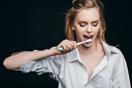 woman in male shirt brushing teethの写真素材