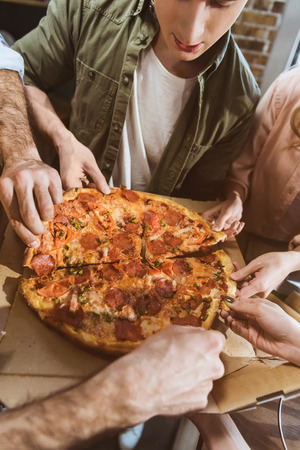 young people eating pizzaの写真素材