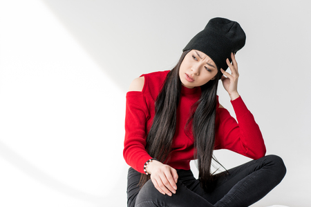 length view of pensive attractive asian woman sittingの写真素材