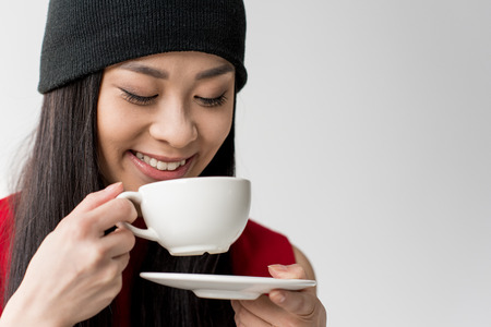 portrait of attractive asian woman holding tea cup isolatedの写真素材
