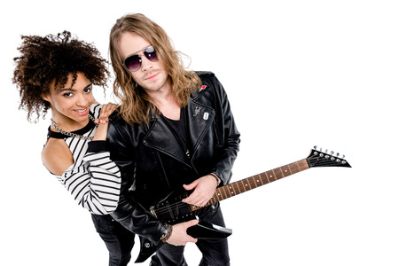 Stylish young couple posing together with electric guitarの写真素材