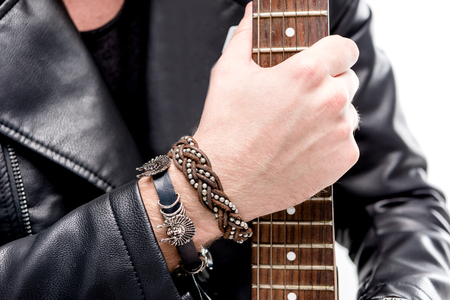 cropped view of rocker in black leather jacket posing with electric guitar isolated on whiteの写真素材