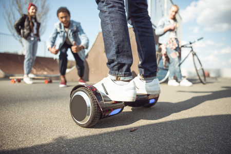 stylish hipster boy riding gyroboard with friends near byの写真素材