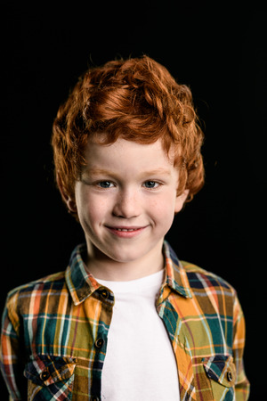 portrait of adorable redhead boy smiling and looking at cameraの写真素材