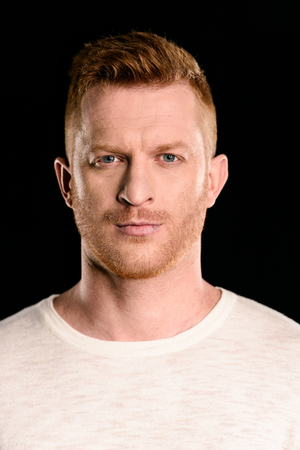 portrait of handsome redhead man posing and looking at camera