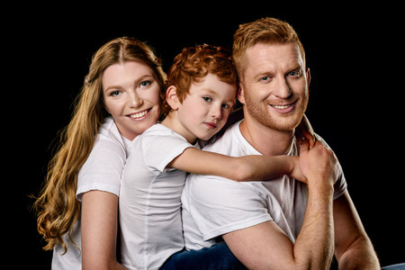 portrait of family in white t-shirts hugging each otherの写真素材