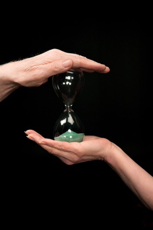 senior couple holding hourglass