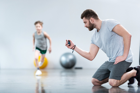 Boy exercising with his coachの写真素材