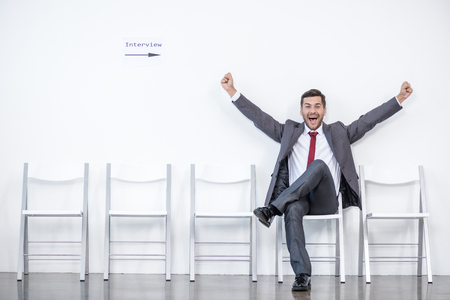 excited businessman sitting and waiting for interview in officeの写真素材