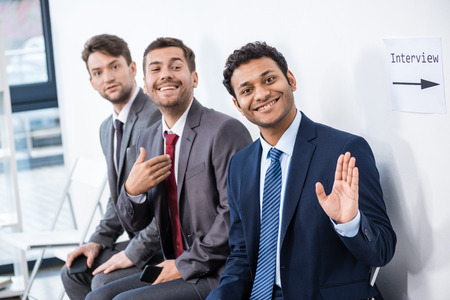 businessmen sitting in queue and waiting for interview in officeの写真素材