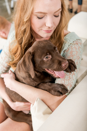 redhead woman holding labrador retriever puppyの写真素材