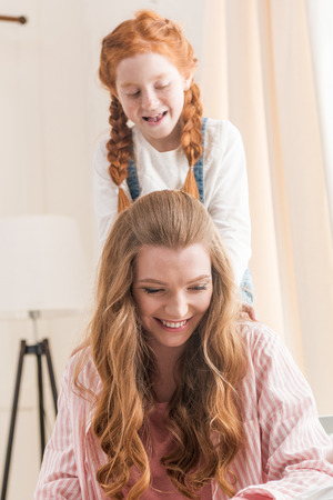 Beautiful happy mother and daughter having fun together at homeの写真素材