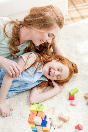 Beautiful happy mother and daughter having fun together at homeの写真素材