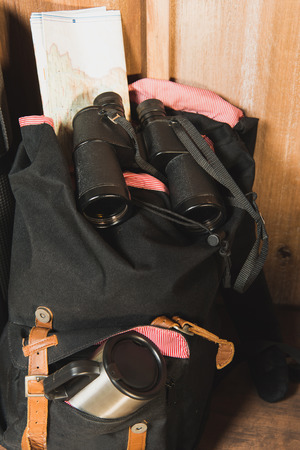 different trekking equipment on bench near wooden house waiting for travelerの写真素材