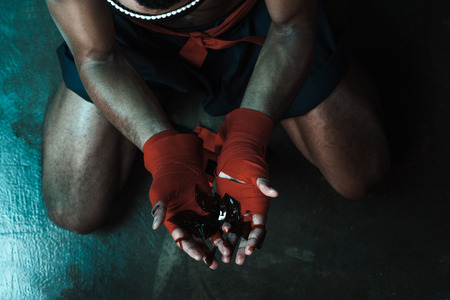 Muay Thai athlete holding glass shatters indoors, fight club conceptの写真素材