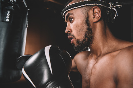 Close-up view of Muay Thai athlete training at Thai boxing with punching bag