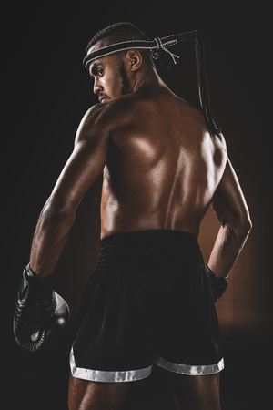 shirtless Muay Thai athlete standing in studio, boxing gloves fight conceptの写真素材