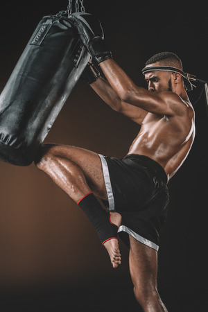 side view of muay thai fighter training with punching bagの写真素材