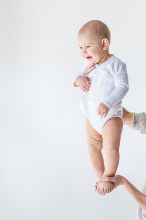 side view of mother holding adorable baby boy isolated on whiteの写真素材