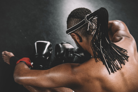 back view of muay thai fighter with mongkhon on head sitting on floorの写真素材
