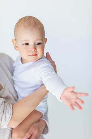 front view of mother holding adorable baby boy isolated on whiteの写真素材