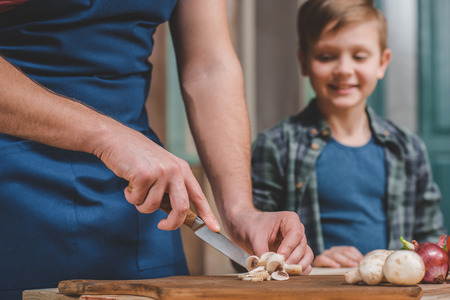 father with little son preparing food on table at backyardの写真素材