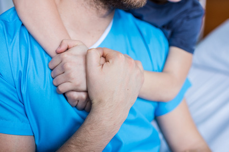 Cropped shot of son hugging sick father, dad and son in hospitalの写真素材