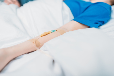 little boy with drop counter sleeping in hospital bedの写真素材