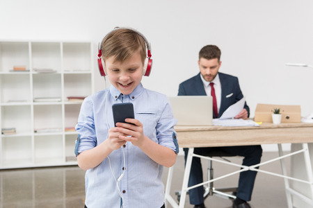 business attire entrepreneur at office with boy listening musicの写真素材