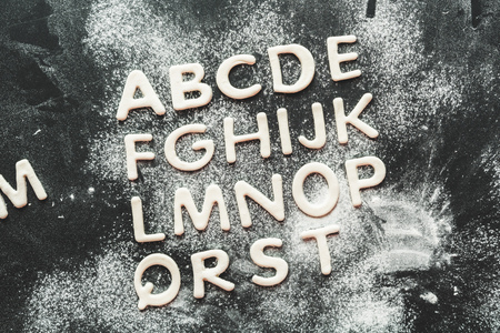 top view of dough for cookies in forms of letters with flour, cookie doughの写真素材