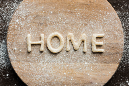 Top view of edible lettering home made from cookies on wooden cutting board, baking cookies conceptの写真素材