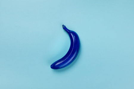 blue colored banana isolated on blue, colorful backgroundの写真素材