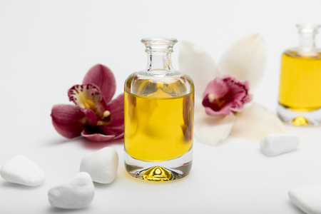 Close-up view of essential oil, white stones and orchids isolated on whiteの写真素材