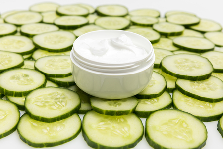 Close-up view of facial cream in container and cucumber slicesの写真素材
