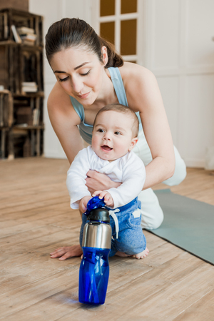 Woman in casual clothes relaxing with her son after fitness workoutの写真素材