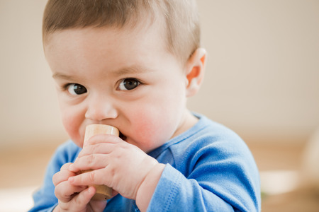 adorable child looking at camera with wooden toy in handsの写真素材
