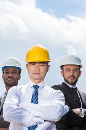 portrait of multiathic group of professional architects in hard hatsの写真素材