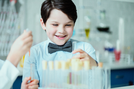 happy schoolboy with flasks in chemical labの写真素材