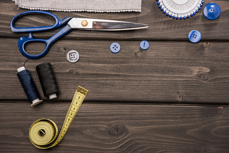 set of various sewing supplies on wooden surface