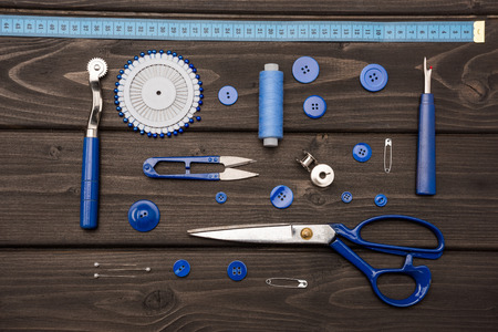 set of various sewing supplies on wooden surface