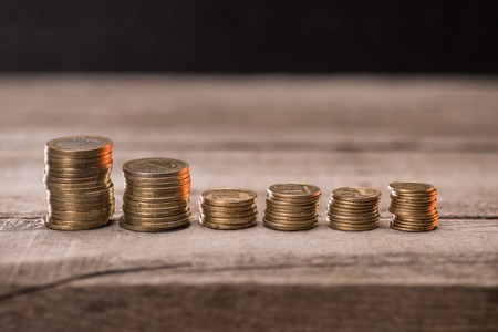 Stacks of coins on wooden tabletop, pile of coins concept