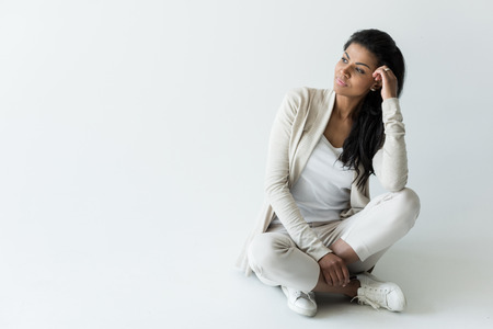 pensive african american woman sitting isolated on white with copy spaceの写真素材