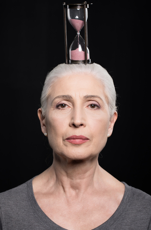 senior woman with sand clock on head