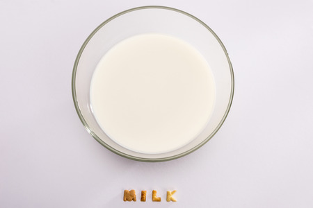 milk in bowl and word milk from corn flakes isolated on greyの写真素材