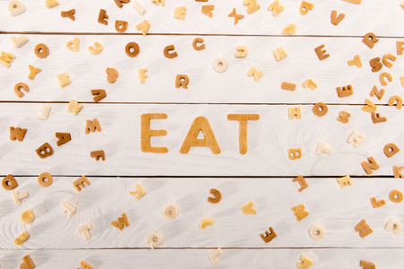 word eat from breakfast cereal letters and alphabet corn flakes on wooden tableの写真素材