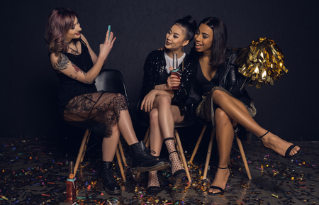woman taking picture of smiling friends during partyの写真素材