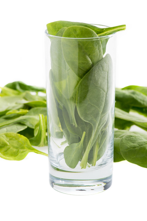 fresh green spinach leaves in glass isolated on white, ingredient for smoothieの写真素材